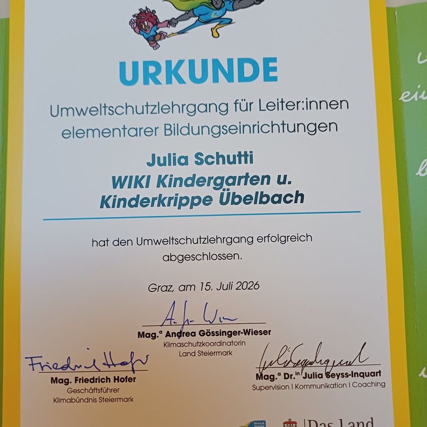 A certificate for Julia Schutti from the WIKI Kindergarten in Ubelbach, Graz, dated July 15, 2026, for completing an environmental protection course. Signed by Andrea Gossinger-Wieser, Climate Protection Coordinator, and Mag. Friedrich Hofer, Business Manager of the Climate Alliance of Styria.