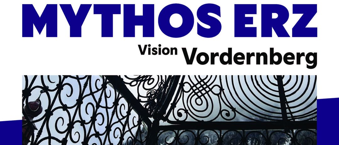 Ein blau thematisches Bild mit dem Wort Mythos in fetten, blauen Buchstaben und dem Wort Vision in kleineren, blauen Buchstaben darunter. Eine schwarze Schmiedeeisenstruktur ist im Vordergrund mit Bergen im Hintergrund.