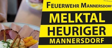 A yellow and black sign with white text reading 'Feuerwehr Melktal Heuriger Mannersdorf' above a plate of food.