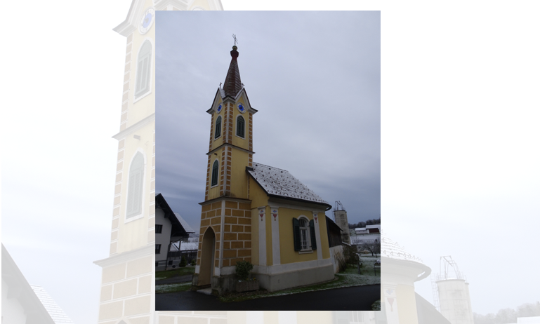 Eine gelbe Kirche mit einem Turm steht in einer ländlichen Gegend und ist gegen einen bewölkten Himmel angesetzt. Der Turm hat blaue Fenster.