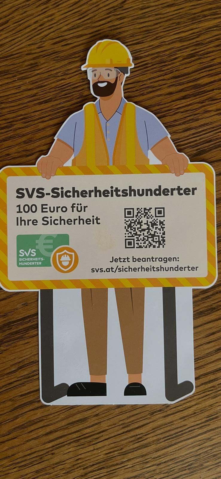 Ein Werbebild zeigt eine Person, die ein Schild mit der Aufschrift 'SVS-Sicherheitshunderter' hält. Es bietet 100 Euro für Sicherheit. Das Schild enthält einen QR-Code, ein Logo und ein Sicherheitssymbol.
