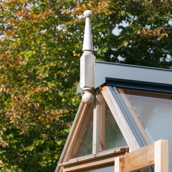 Nahaufnahme einer Ecke eines Gewächshauses mit einer Metallspitze in der Ecke.