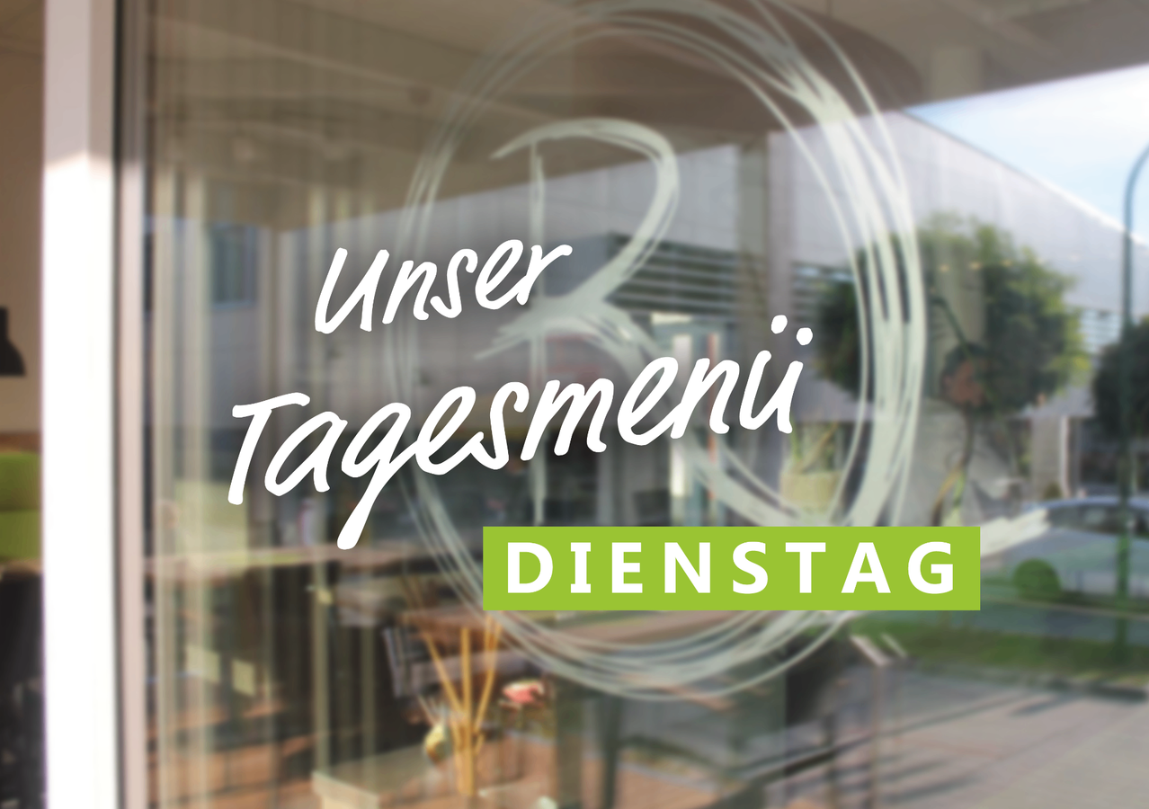 A blurred background with a restaurant's glass door displays the text 'Unser Tagesmenu Dienstag' in white. The image shows an interior view with tables and chairs.