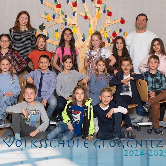 Eine Gruppe von Kindern und zwei Erwachsenen posiert für ein Foto an der Volksschule Gloggnitz im Jahr 2024-2025.