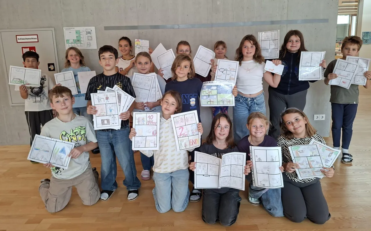 Eine Gruppe von Kindern posiert für ein Foto, während sie ihre Zeichnungen hochhalten.