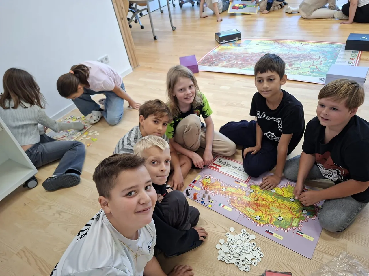 Eine Gruppe von Kindern sitzt auf dem Boden und spielt ein Brettspiel.