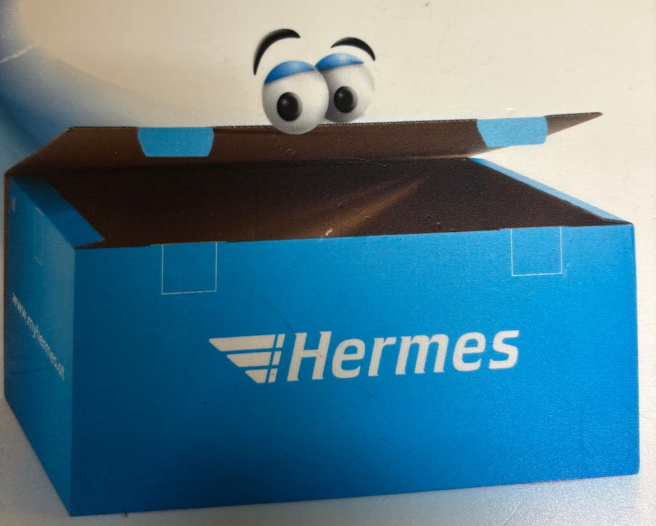 Offene Hermes-Lieferbox mit einem gezeichneten Auge, das von oben herauslugt.
