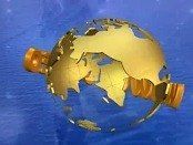 A golden globe is floating in the blue sky, with a large star on its surface and two golden rings attached to it. The globe appears to be floating above a blue ocean.