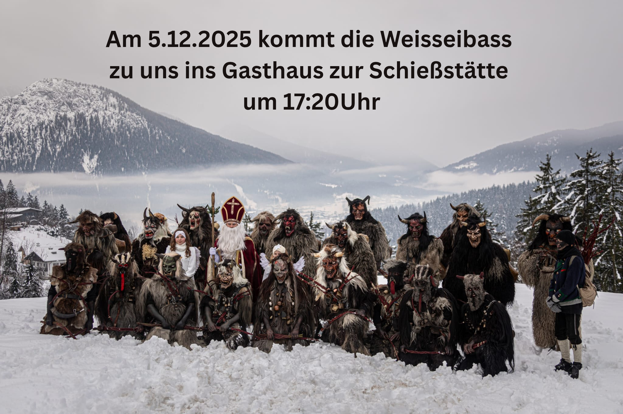 Am 5.12.2025 kommt die Weisseibass zu uns ins Gasthaus zur Schießstätte um 17:20 Uhr. Eine Gruppe von Personen in Kostümen posiert im Schnee mit Bergen im Hintergrund.