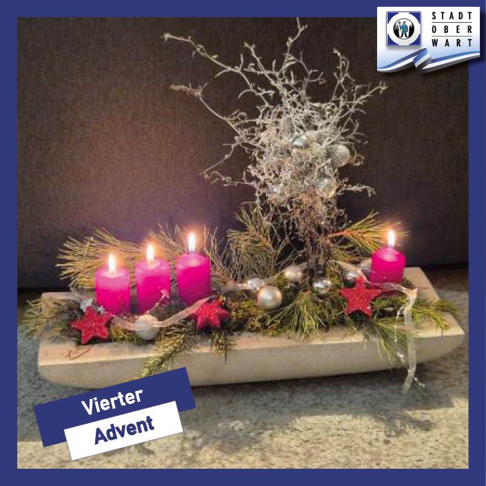 Ein Holztablett hält vier rosa Kerzen, umgeben von grünen Zweigen und silbernen Ornamenten. Der Text darunter lautet Vierter Advent.