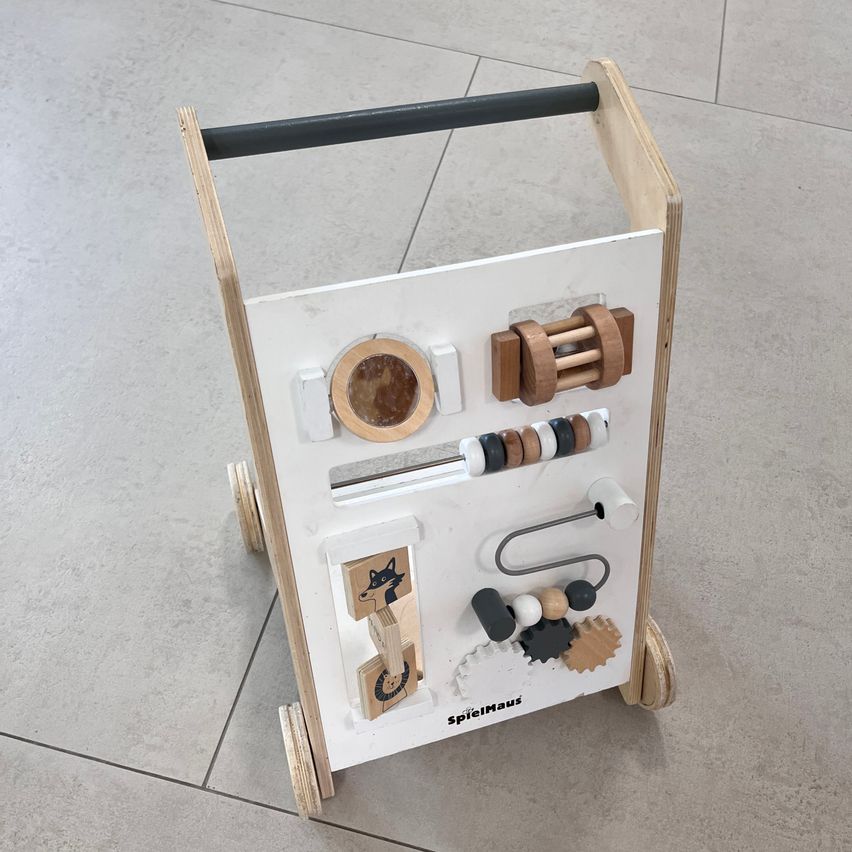 Ein holzernen Lernspielzeug mit verschiedenen Komponenten, einschließlich eines Holzgriffs, eines kreisförmigen Objekts und einer Fuchsillustration, entwickelt, damit Kinder durch Spielen lernen.