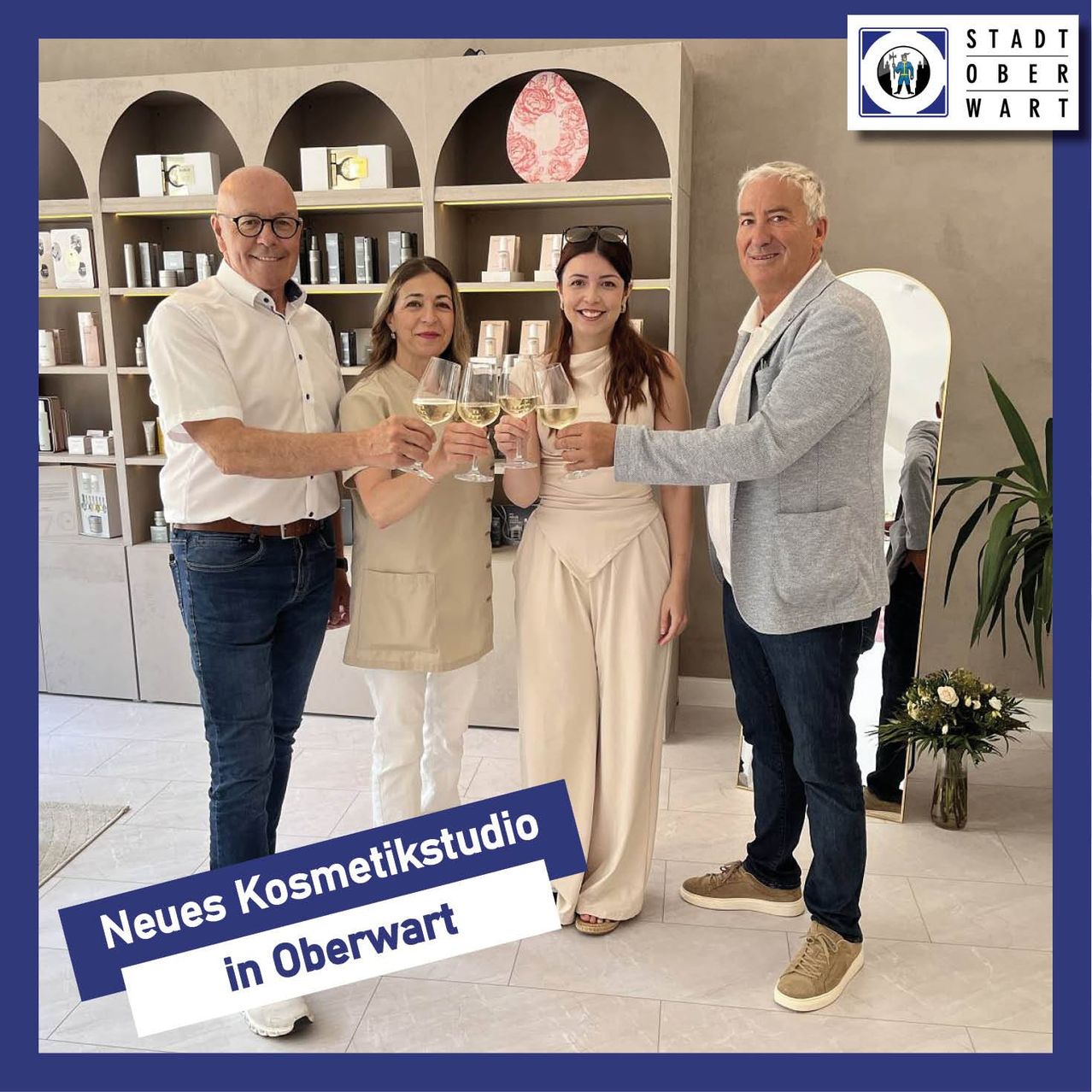 Vier Personen stehen in einem Kosmetikstudio. Sie halten Weingläser und stoßen an. Ein Schild sagt Neues Kosmetikstudio in Oberwart.