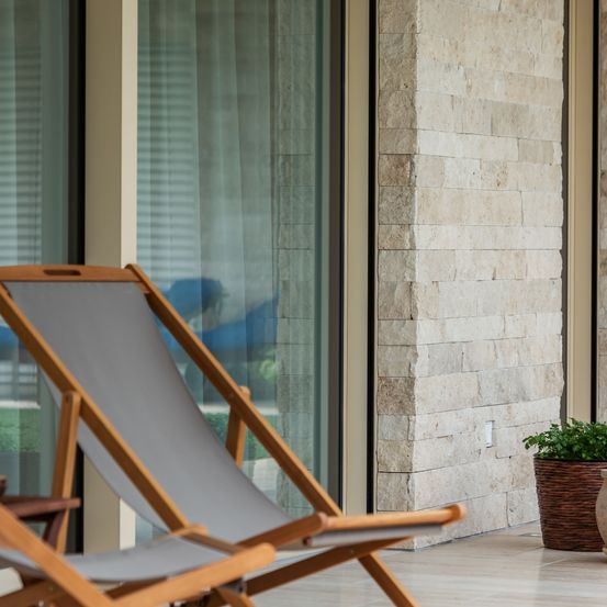 Bild enthält, Plant, Architecture, Balcony, Building, Chair, Furniture, Indoors, Interior Design, Person