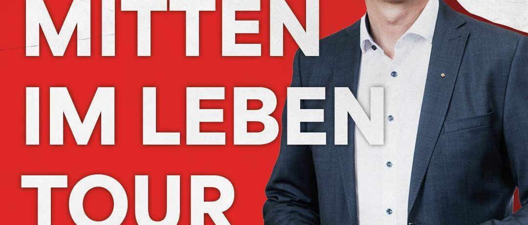 Ein Werbebild für eine politische Veranstaltung in Österreich. Ein lächelnder Mann in einem Anzug ist zu sehen, mit dem Text 'Mitten im Leben Tour', Datum 'Samstag, 17. Jänner 2026' und Ort 'Traunungssaal Voelkermarkt'.