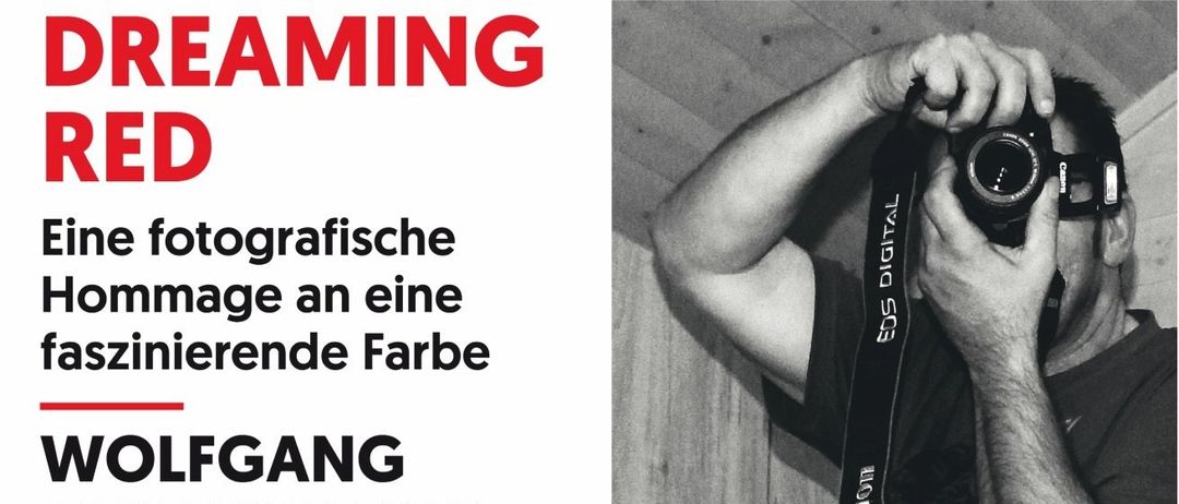 Ein Ausstellungsplakat für Wolfgang Jagersbergers 'Dreaming Red'. Es zeigt ein Foto eines Mannes mit Kamera und eines mit roten Objekten. Die Veranstaltungsdetails umfassen Eröffnung, Dauer und Zeiten.