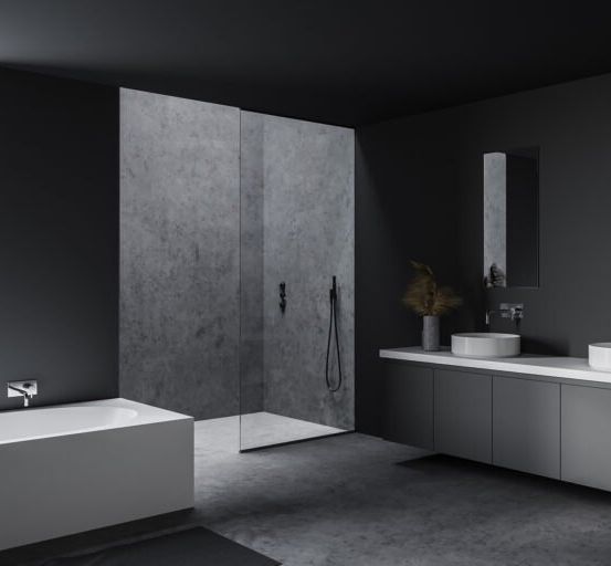 Modernes Badezimmer mit grauen Wänden, einer Badewanne, zwei Waschbecken und einer Duschkabine mit Glastür.