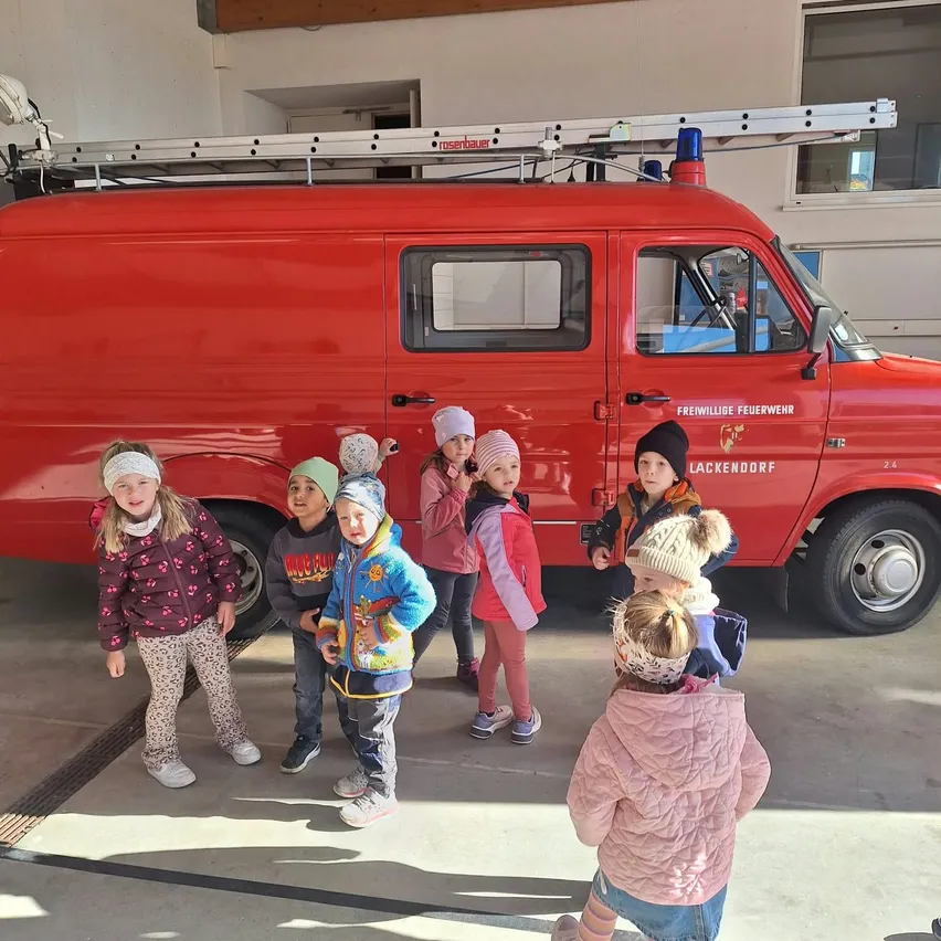 Kinder vor dem roten Feuerwehrauto der Freiwilligen Feuerwehr Lackendorf