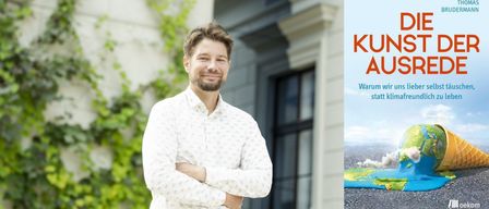 Ein Mann in einem weißen gemusterten Hemd steht lächelnd vor einem Gebäude mit verschränkten Armen.