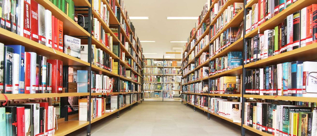 Bild enthält, Furniture, Architecture, Building, Indoors, Aisle, Bookcase, Book, Library, Person