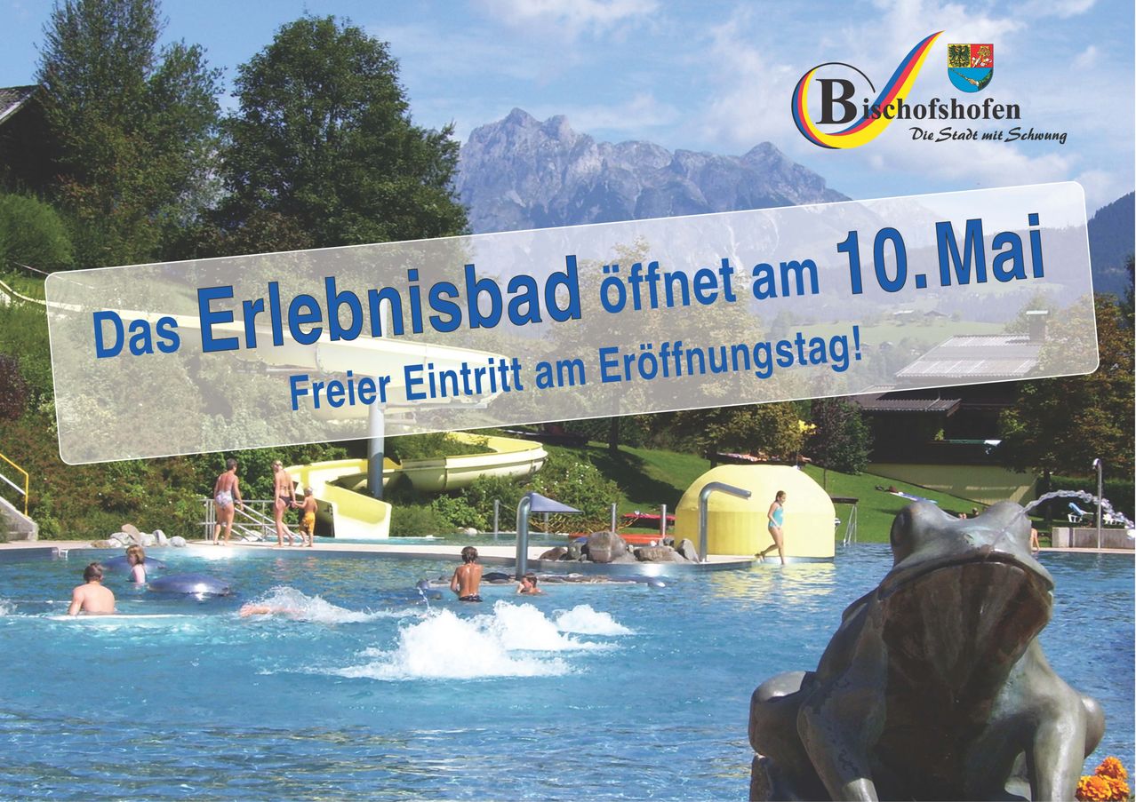 Ein Freibad mit Bergblick. In der Nähe sind eine Rutsche und ein Brunnen. Einige Leute schwimmen und spielen. Ein Werbebanner ist oben angebracht.