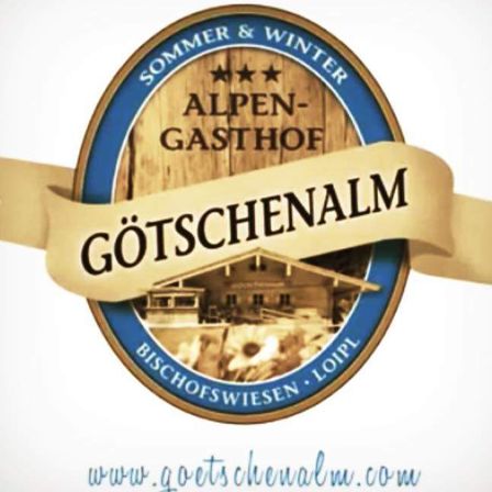 Das Logo des Goetschenalm Alpine Gasthofs mit einem Holzfass-Design, Sternen und einer malerischen Berglandschaft. Website: www.goetschenalm.com.