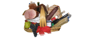 Ein Korb gefüllt mit verschiedenen Lebensmitteln, darunter Schinken, Trauben, Brot, eine Flasche Wein und ein Glas Marmelade.