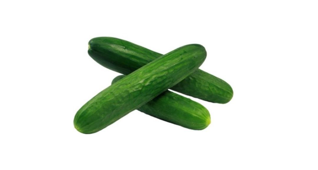 Drei frische grüne Gurken in einer dreieckigen Form auf einem weißen Hintergrund angeordnet.