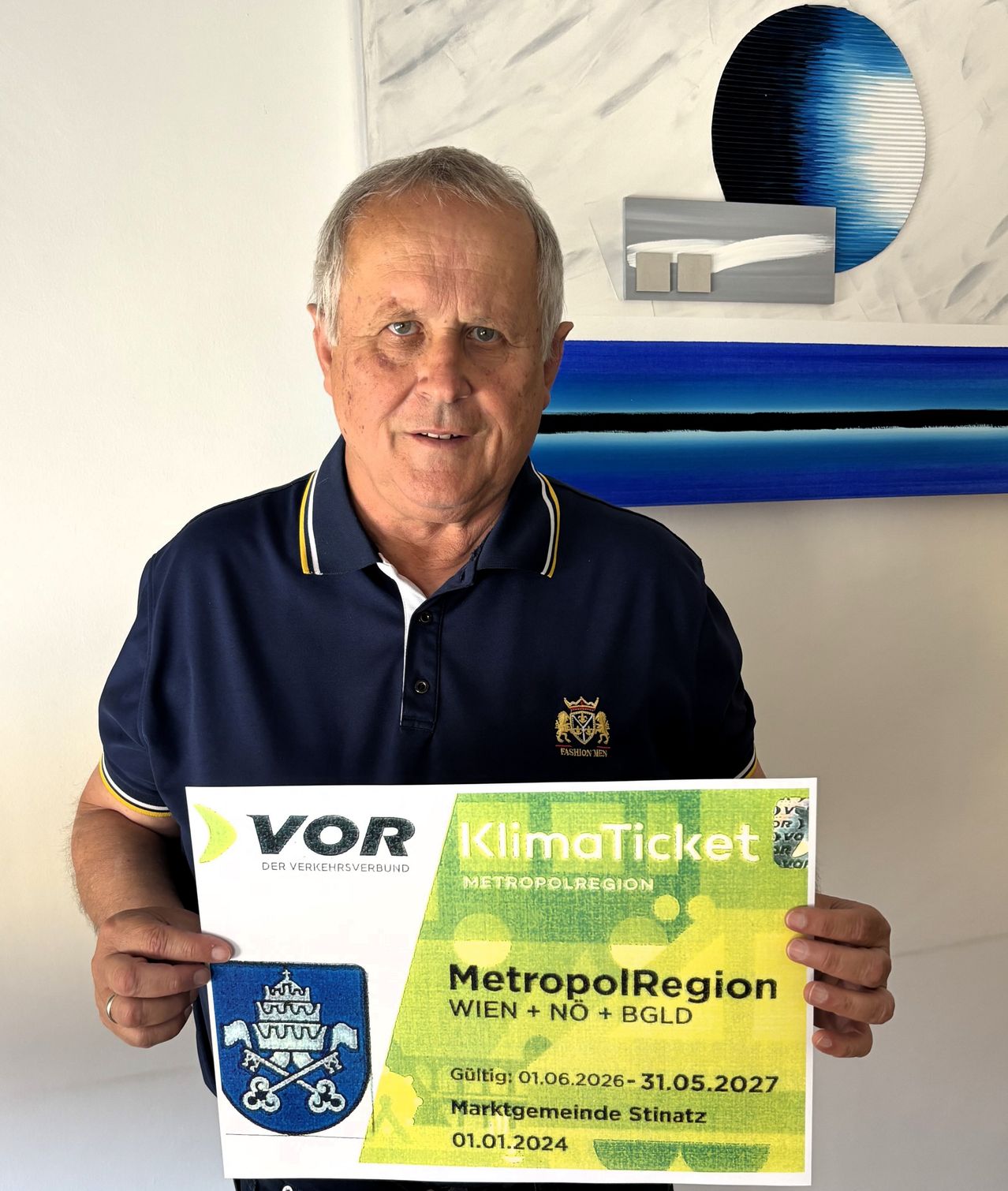 Ein älterer Mann hält ein KlimaTicket von MetropolRegion, gültig vom 01.06.2026 bis 31.05.2027, für Wien, Niederösterreich und Burgenland.