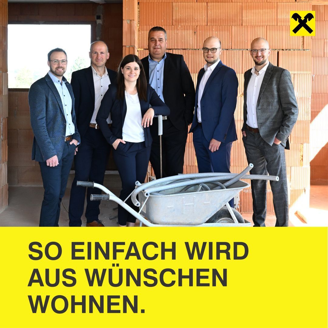 Sechs Personen, vier Männer und zwei Frauen, stehen vor einer Ziegelwand. Sie sind in Geschäftskleidung gekleidet. Vor ihnen steht eine Schubkarre mit Rohren. Ein gelbes Banner mit weißem Text lautet, 'SO EINFACH WIRD AUS WÜNSCHEN WOHNEN.'
