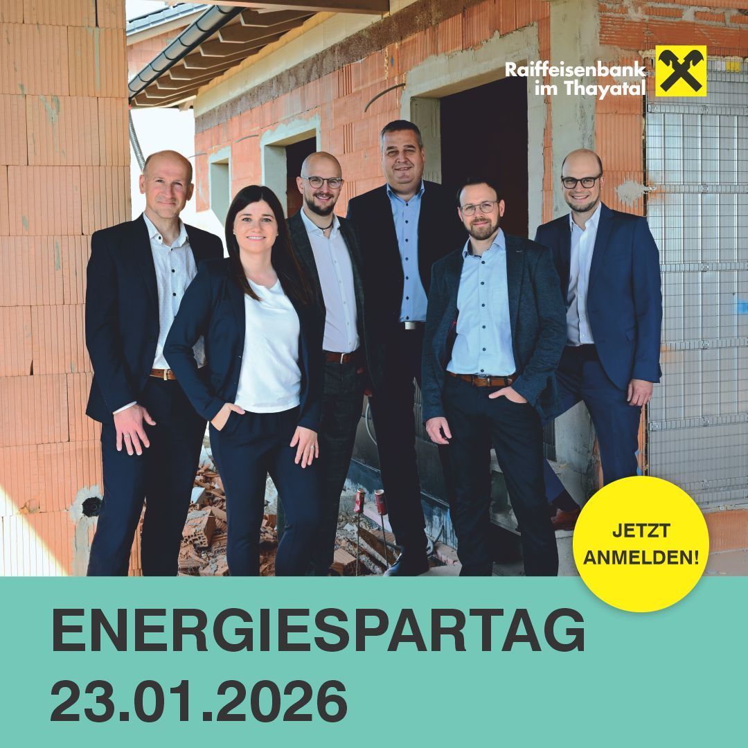 A group of people stands in front of a construction site with a sign reading Energiespartag and a date of 23.01.2026. They wear business suits. Behind them, a building under construction is visible.