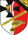 Das Emblem zeigt einen Schild mit einem schwarzen Kreuz auf weißem Hintergrund, einem roten Feld mit weißen Streifen, einer goldenen Flamme und einer Medaille. Der Text 'OKB Pregarten' ist in Gelb geschrieben.