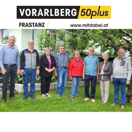 Eine Gruppe Erwachsener steht vor einem Haus in Frastanz, Vorarlberg, für ein Foto. Sie lächeln und sind lässig gekleidet. Dahinter befindet sich ein Garten mit Pflanzen und einem Baum.