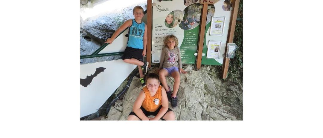 Poster für eine spezielle geführte Höhlenführung für Kinder im Alter von 6-12 Jahren. Es zeigt ein Foto von Kindern, die eine Höhle erkunden, mit einem Schild im Hintergrund. Die Veranstaltung umfasst Geschichten, Höhlenlebenserfahrungen und ein Höhlenquiz mit einer 3D-Karte als Preis. Geplant für den 21. Juli und 4. August 2026 um 10:00 Uhr und 14:00 Uhr. Warme Kleidung und gute Schuhe sind erforderlich.