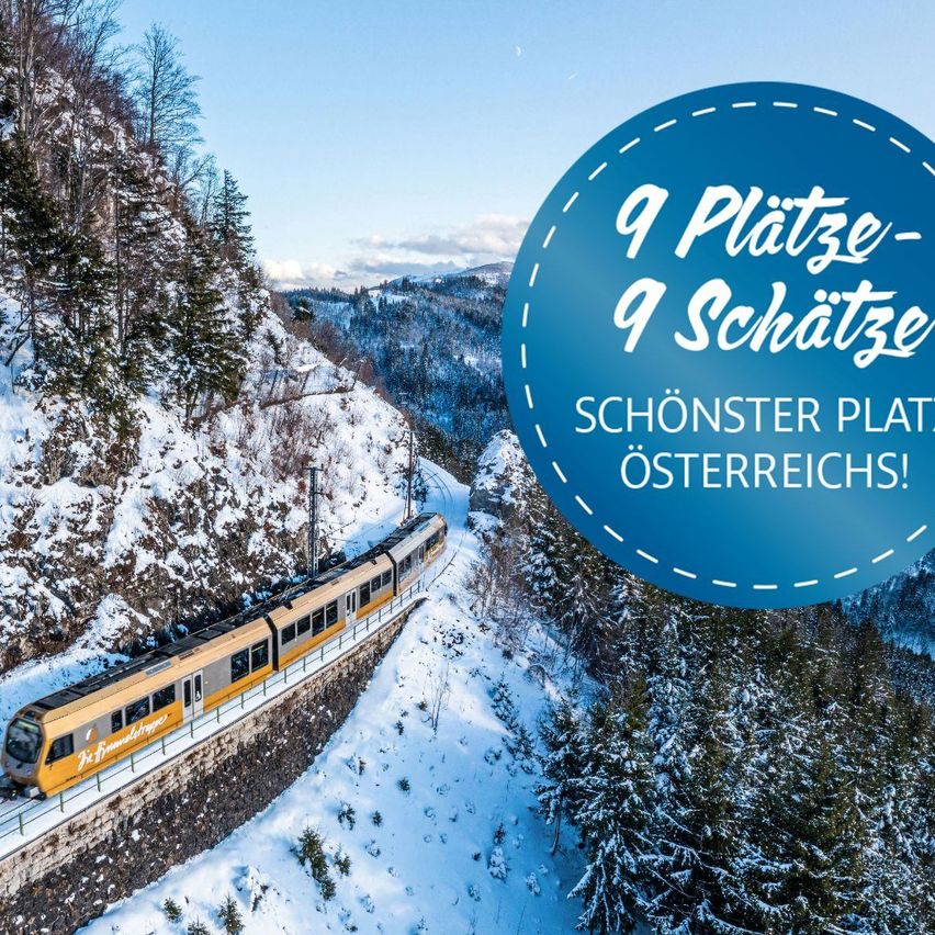 Ein Zug fährt auf einem verschneiten Berghang mit einem blauen Kreis-Grafik im Zentrum, der '9 Plätze - 9 Schätze - Die schönsten Orte Österreichs!' besagt.