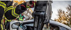 Ein Feuerwehrmann in Helm und Uniform arbeitet an einem Fahrzeug, möglicherweise wird es repariert. Der Text oben erklärt die Notwendigkeit alter Fahrzeuge für verschiedene Szenarien, nicht unbedingt verkehrstauglich.