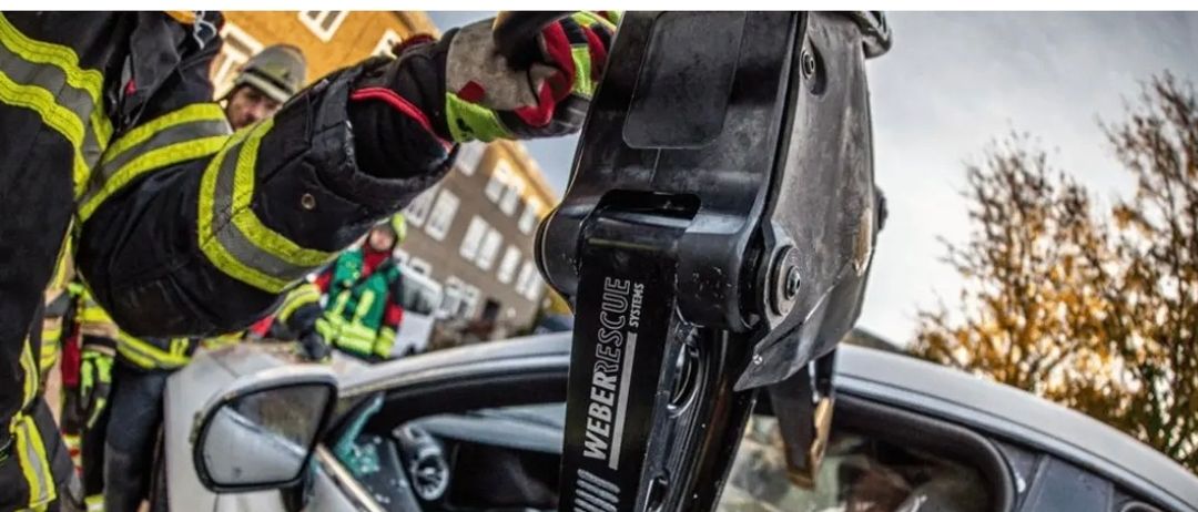 Ein Feuerwehrmann in Helm und Uniform arbeitet an einem Fahrzeug, möglicherweise wird es repariert. Der Text oben erklärt die Notwendigkeit alter Fahrzeuge für verschiedene Szenarien, nicht unbedingt verkehrstauglich.