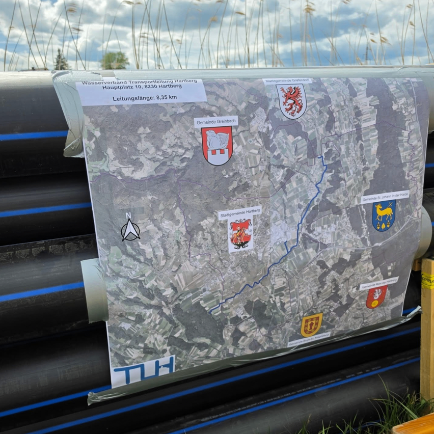 Eine Karte mit verschiedenen lokalen Wappen, die auf einem Brett befestigt sind und eine Route mit mehreren Markierungen und Entfernungen zeigt.