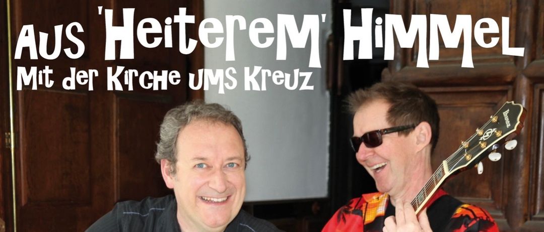 Zwei Männer, einer hält ein kleines Kirchenmodell, der andere spielt Gitarre, lächeln für ein Plakat. Auf dem Plakat steht: Oliver Hochkofler & Imo Trojan. Einladung zum gemeinsamen Lachen am Freitag, 10. April 2026, um 18 Uhr. QR-Code und Ticketpreise sind ebenfalls angegeben.