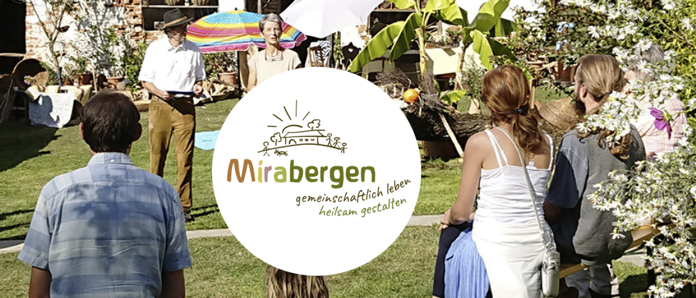 Menschen sitzen in einem Garten und hören einer Frau zu. Der Mann hält ein Buch in der Hand und steht neben Regenschirmen. Ein Gebäude mit Pflanzen ist im Hintergrund. Das Wort Mirabergen ist zu sehen.