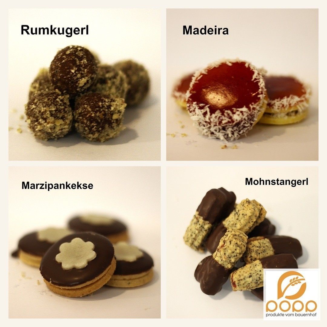 Vier Arten von Süßigkeiten werden gezeigt: Rumkugeln, Madeira, Marzipankekse und Mohnstangerl. Die Rumkugeln sind schokoladenüberzogene Kugeln, Madeira ist ein mehrschichtiges Gebäck, Marzipankekse sind Kekse mit Schokoladenüberzug und Mohnstangerl sind Mohnstangen.