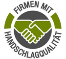 A circular logo with two hands shaking, the text reads 'Firmen mit Handschlagqualitat' in white font. The hands are green and gray, and the background is gray.
