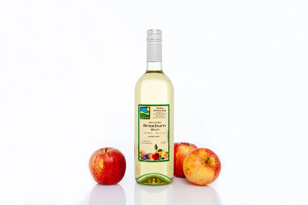 A bottle of Braeburn cider with two red apples on either side. The cider is in a clear bottle with a green label.