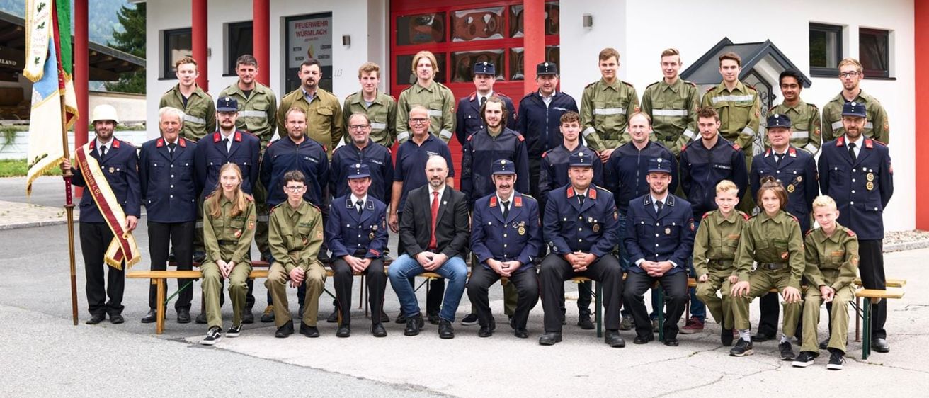 Bild enthält, People, Person, Clothing, Coat, Fire Station, Vehicle, Groupshot, Footwear, Shoe, Glasses