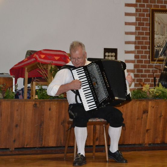 Bild enthält, Potted Plant, Adult, Male, Man, Person, Wood, Shoe, Solo Performance, Glasses, Musical Instrument
