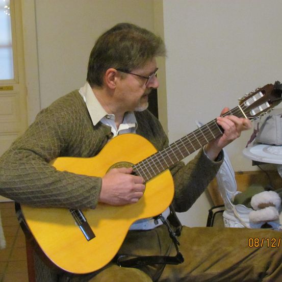 Bild enthält, Guitar, Musical Instrument, Adult, Male, Man, Person, Face, Head, Guitarist, Lute