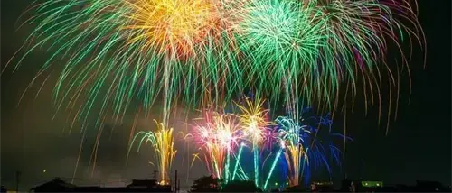 Ein leuchtender Nachthimmel, gefüllt mit mehrfarbigen Feuerwerken, die die Dunkelheit erhellen und eine atemberaubende Lichtshow erzeugen.