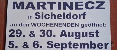 Plakat für Buschenschank Martinec in Sicheldorf, Österreich, an Wochenend geöffnet: 29. & 30. August und 5. & 6. September ab 15 Uhr. Mit Karte und Holztür.