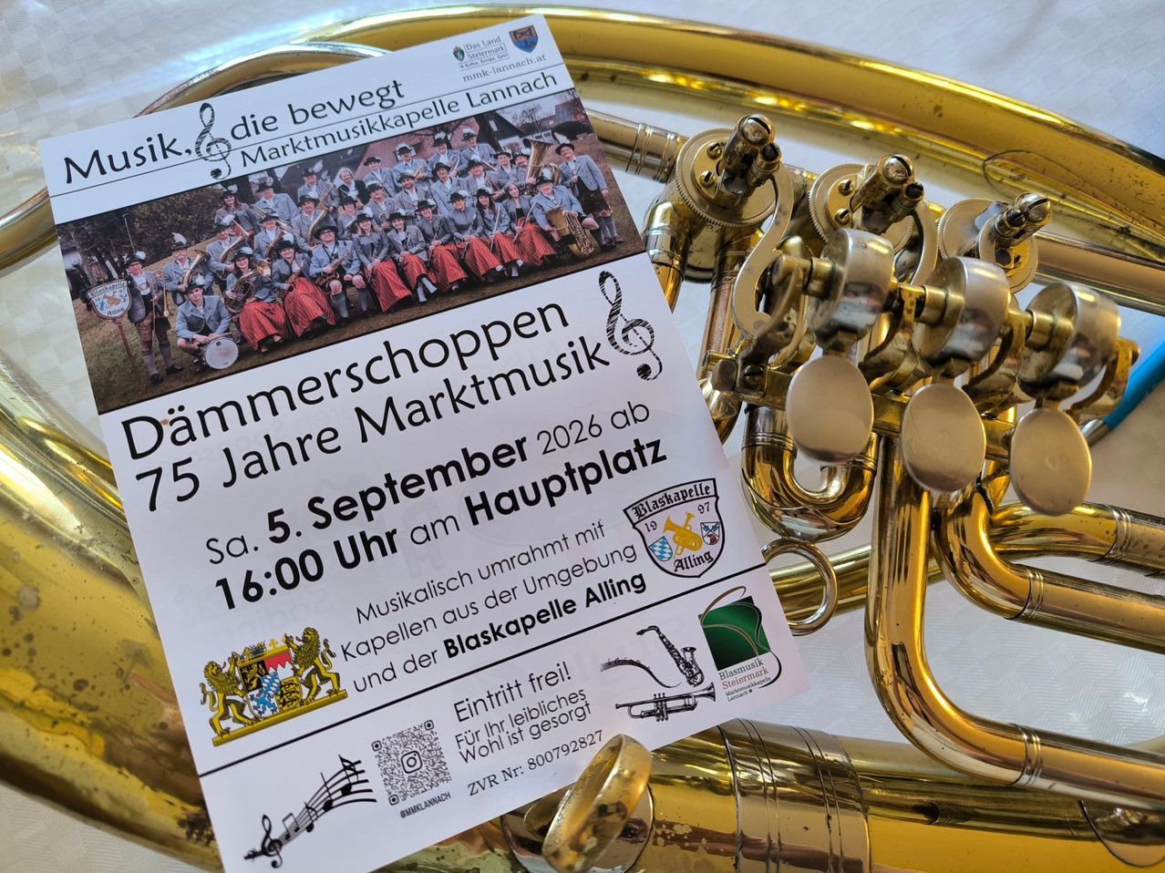 Ein Plakat für ein Blasmusik-Event in Alling, Deutschland, das eine Gruppe von Musikern in Uniform zeigt, mit Angaben zum Datum und zur Uhrzeit der Veranstaltung sowie einem QR-Code für weitere Informationen.