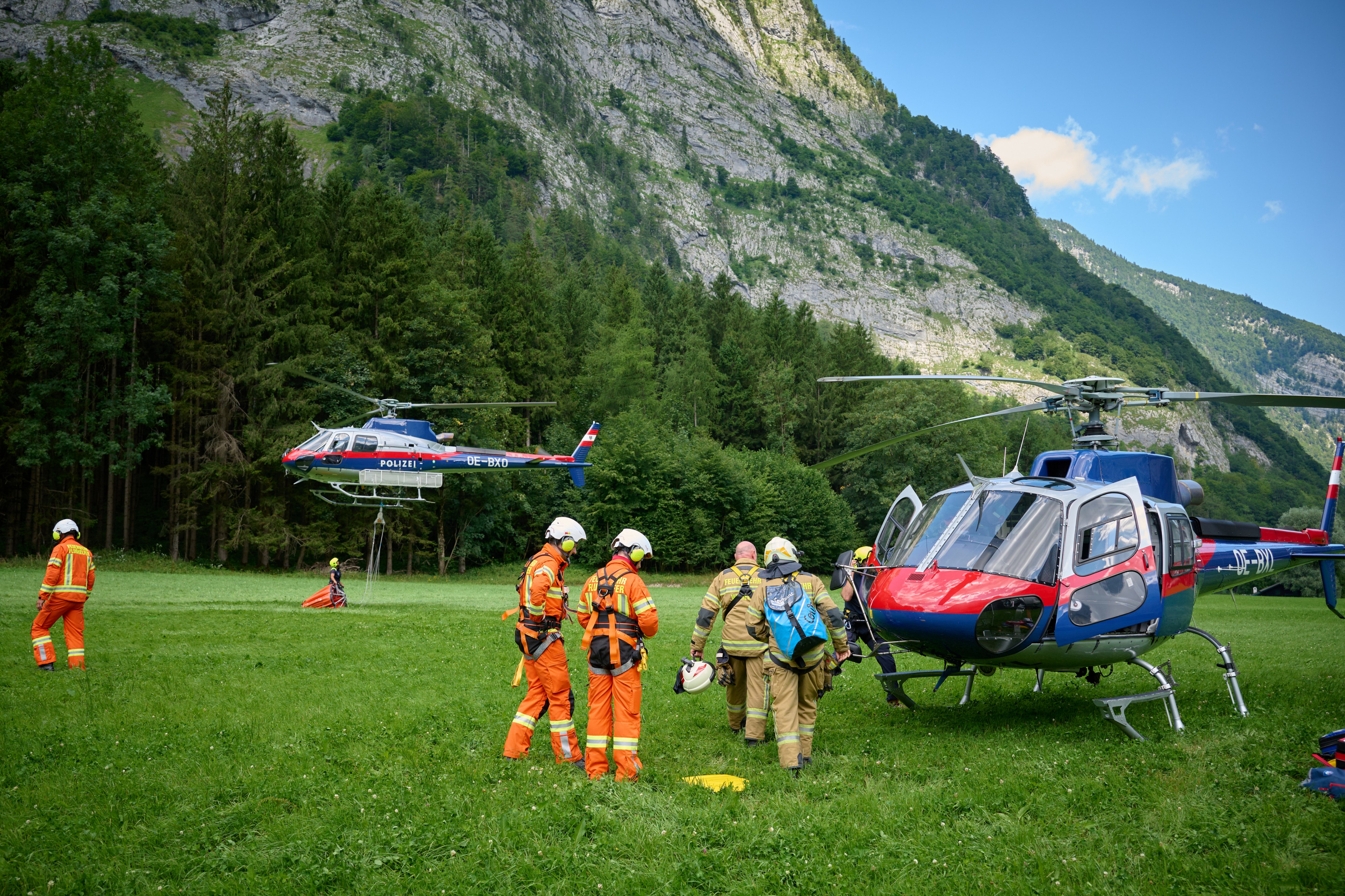 Bergrettungseinsatz mit Polizei- und Rettungshubschraubern in den österreichischen Alpen.
