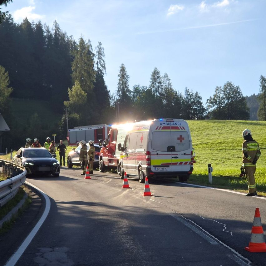 Emergency vehicles are parked on the side of a road with traffic cones and a firefighter standing nearby.
